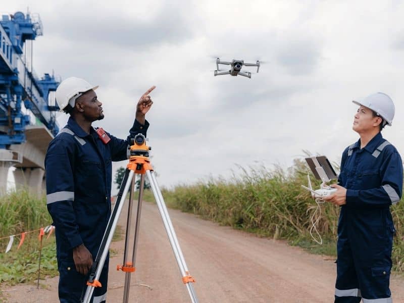 Land surveyors using drone and GPS equipment for LiDAR mapping to monitor shoreline changes and protect waterfront properties over time.