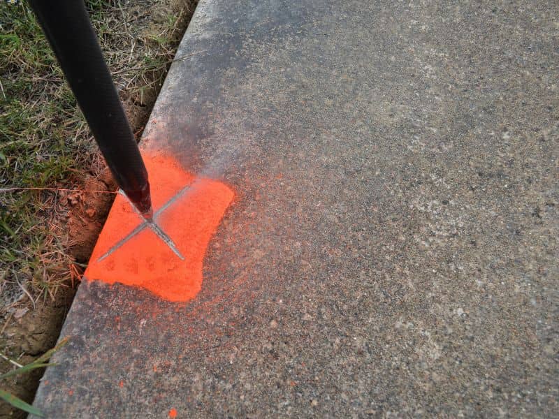 Property line marker beside a sidewalk during curb and utility work in Toledo, Ohio